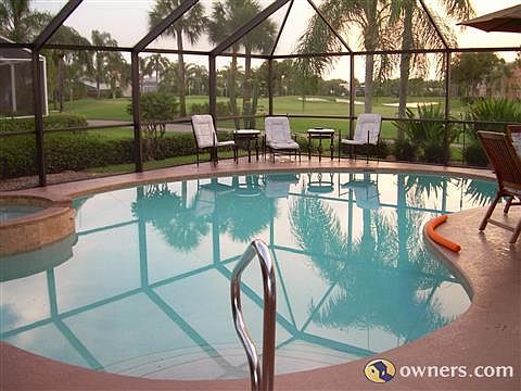 The sun shines all day on the oversized kidney shaped pool.