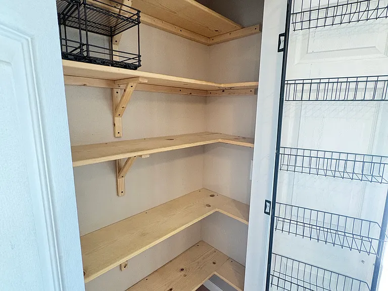 Custom-built, spacious pantry offering ample storage, including a snack rack on the door for a quick grab on the way out to the back patio.