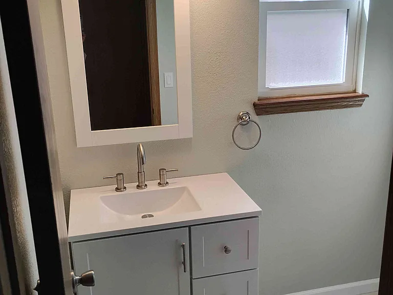 Half-bath on the main floor. New cabinet, sink, faucet, toilet and tile.