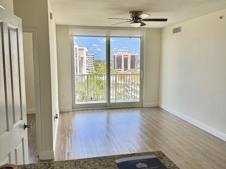 Spacious Living Room with Ceiling Fan and Balcony Views