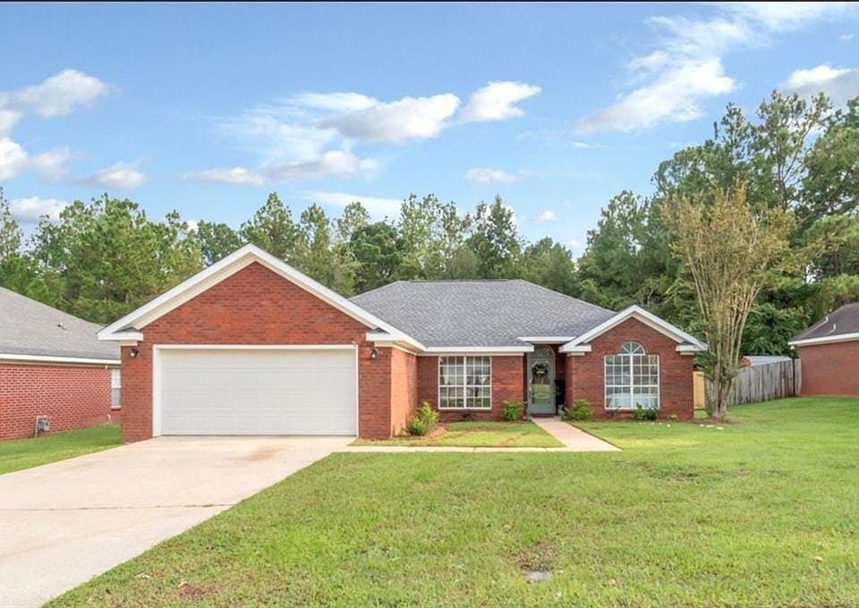 Ranch-style house with a garage and a front lawn