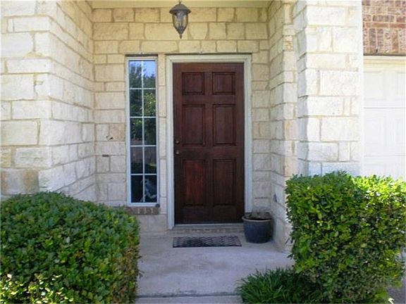 Wood front door with stone features and high ceiling.