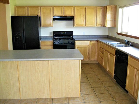 Tiled Kitchen With Large Peninsula Counter. Fridge, Range, and Dishwasher Included.