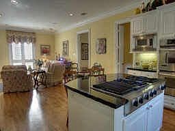 Island kitchen is open to breakfast area and den and features granite counters, stainless appliances