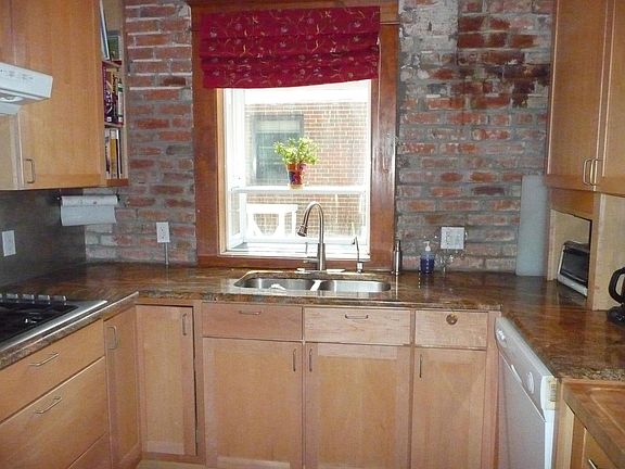 Kitchen with bay window. shows goose kneck faucet, dishwasher on the right, and a gas stove top on the left. Lots of sotrage.
