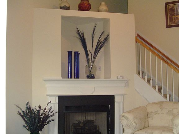 2-story Living Rm features ceiling fan, and cozy gas log fireplace w/ TV nook.