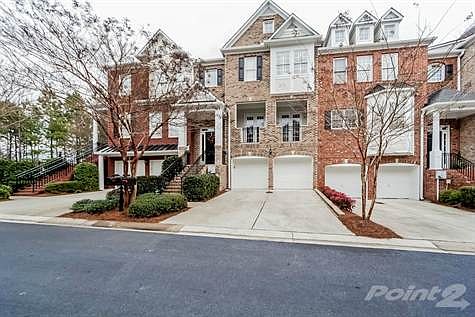 Pulling up to the townhome, you first notice the stunning classic brick exterior with wrought iron railings and an alluring private covered patio.