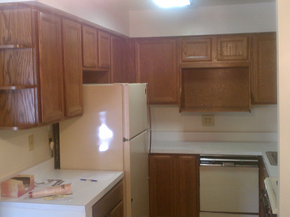 Kitchen with refrigerator and seperate shelf for microwave.