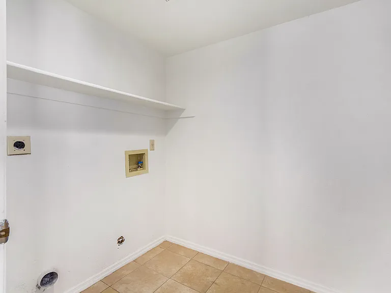 INSIDE laundry hook ups. Room features wall to ceiling shelving fir storage on opposite wall.