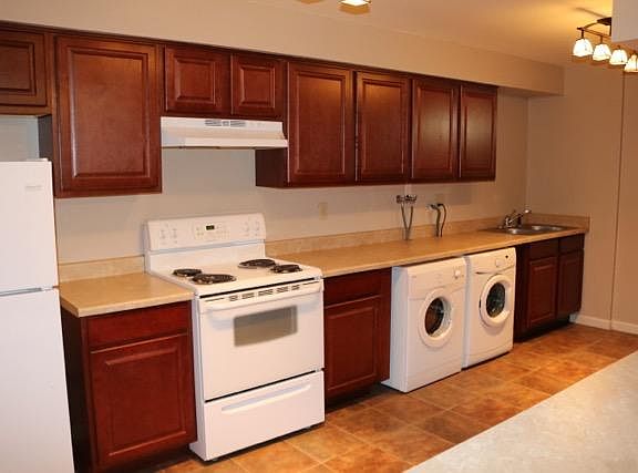 kitchen with fridge, microwave, stove and washer/dryer