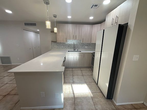 Kitchen with beautiful iridescent backsplash & LED colorful lights hidden behind the cabinets.
