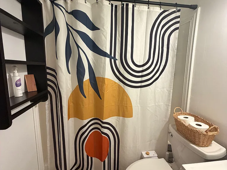 Full bath with tub/shower combo, window for ventilation, and vanity with storage for daily essentials.