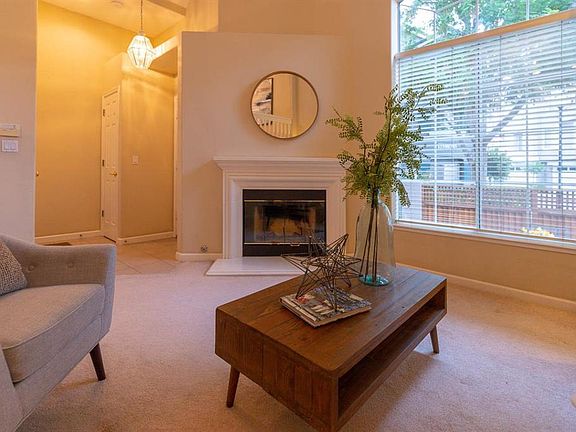 Living Room w/lots of natrual light, Cozy Fireplace & Vaulted Ceilings
