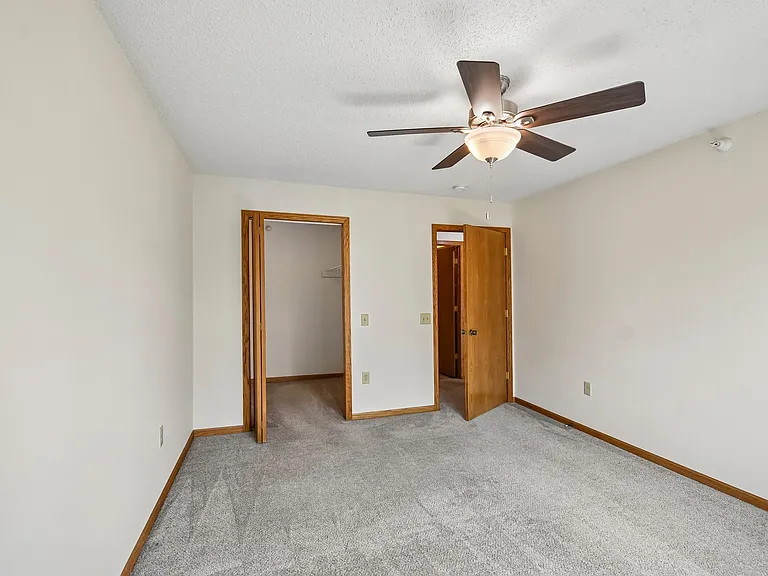 Step into the inviting space of Mill Pond Apartments, featuring a spacious bedroom with plush carpeting and a ceiling fan for optimal comfort. Perfectly designed for your lifestyle, this apartment is ready for you to make it your own. Schedule a tour toda