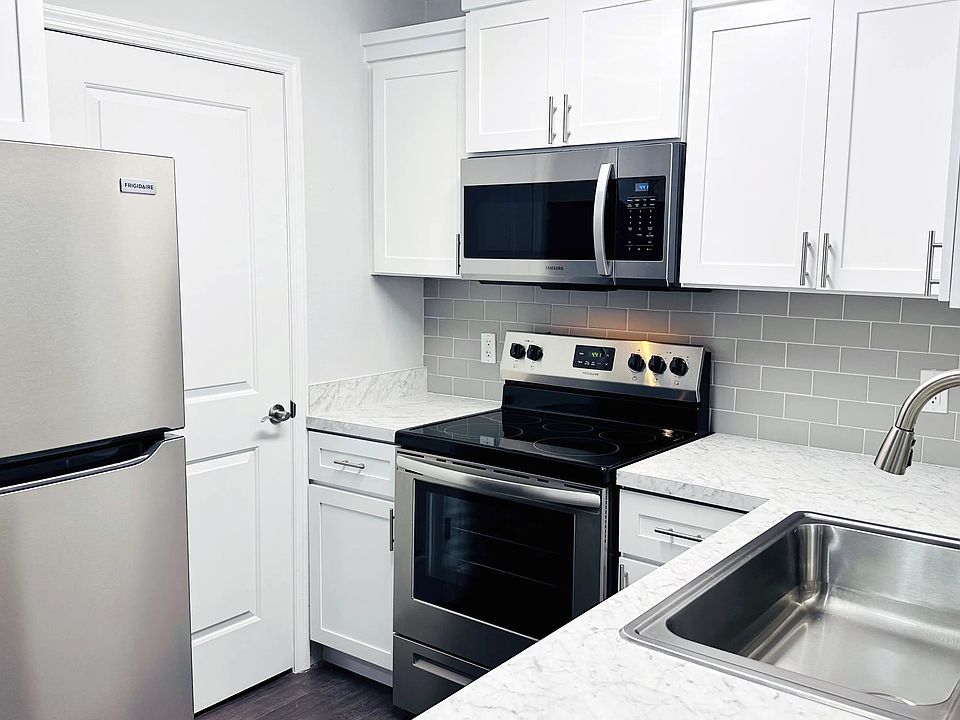 Indulge in our premier kitchens featuring white shaker cabinetry, grey subway tile backsplashes, and gleaming stainless-steel appliances through stunning renovations.