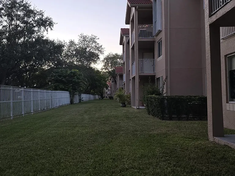 Back area of unit, across from a park with a lake, child playground, dog area, pool, and mini-beach