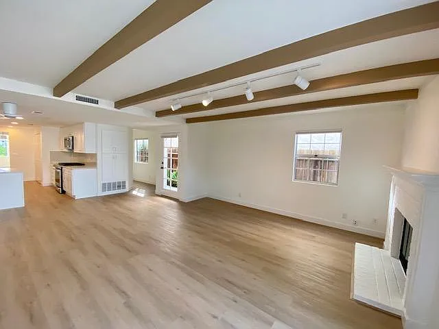 Family room with new flooring, pantry, cabinetry and tract lighting.