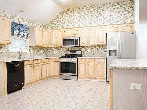Spacious Kitchen with new granite countertop, Gas Range, built-in microwave, dishwasher, refrigerator with water dispenser.