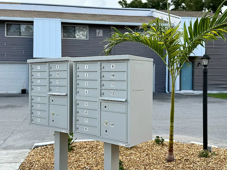 Charming apartment complex with modern mailbox system set amidst lush landscaping and sleek architectural design.