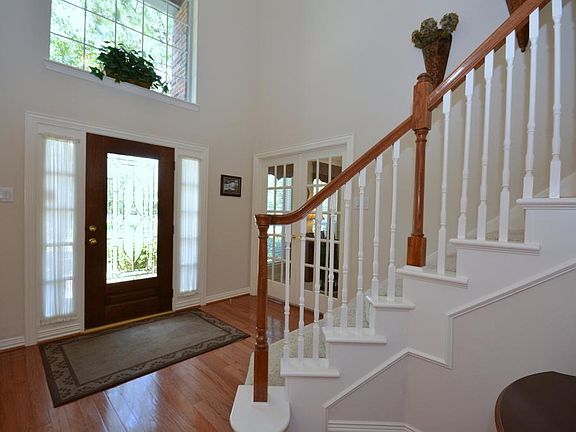 The inviting front yard is accented by mature shade trees and leads to the leaded glass door that op