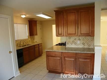 Looking towards the brand New Kitchen : Cabinets, granite, travertine backsplash, and all new applia