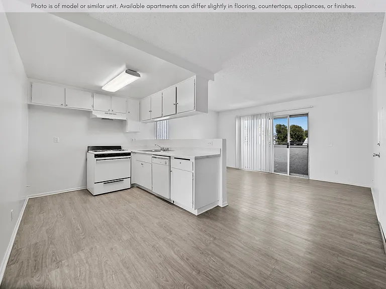 Bright open-concept living and dining area featuring updated flooring, natural light, and a private balcony.