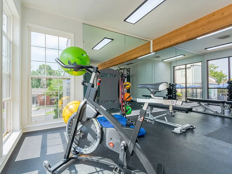 A spin bike looks out through floor to ceiling windows in the fitness center at ReNew on Cantrell.
