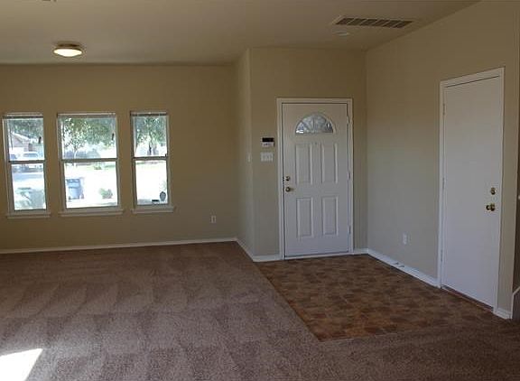 Formal living room looking at entry door and garage door.  New carpet and interior paint throughout.