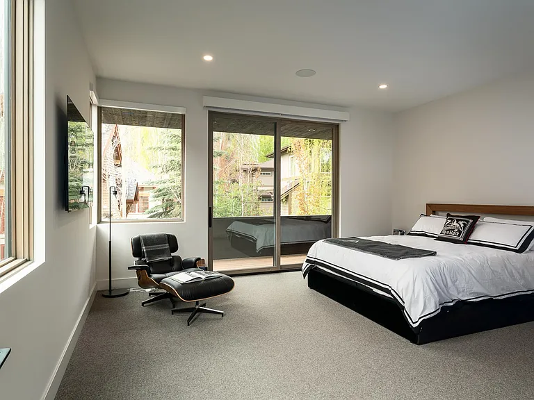 Spacious Master Bedroom with automated window shades, flat screen TV and private deck access.