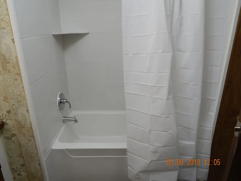Bathtub with shower curtain.