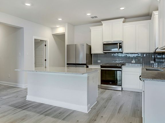The kitchen has beautiful white cabinetry.