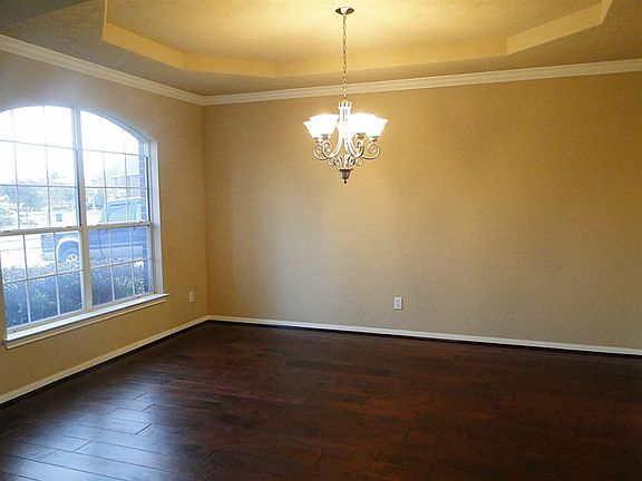 Formal dining with hardwood floors and tray ceiling.
