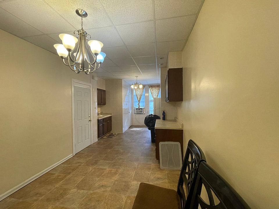 Kitchen with entrance to left. Bathroom door near window.