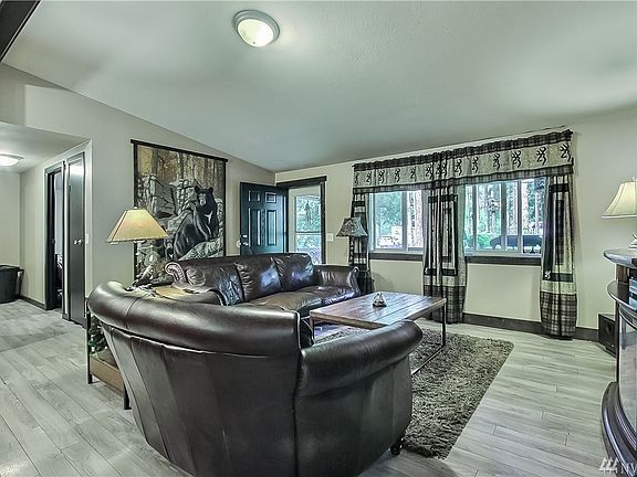 Shot from dining area toward living room and entry. Great flooring and cathedral ceilings. 