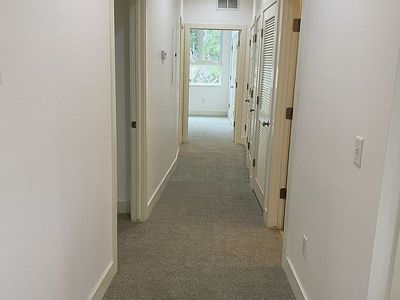 Hallway to bedrooms, bathrooms, and storage area.