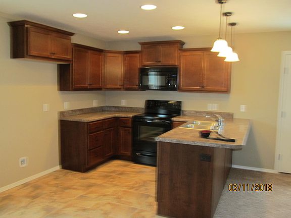 View of kitchen from the dining area which is tiled.
