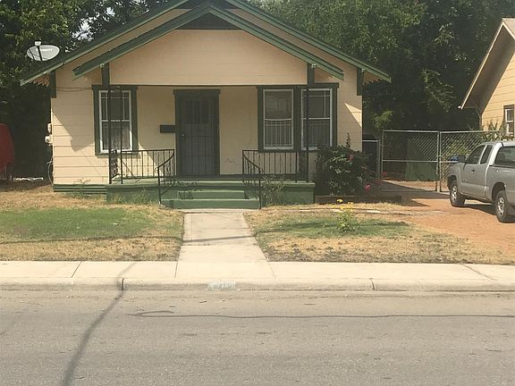 Exterior photo of front of 407 Canton with driveway and fence view