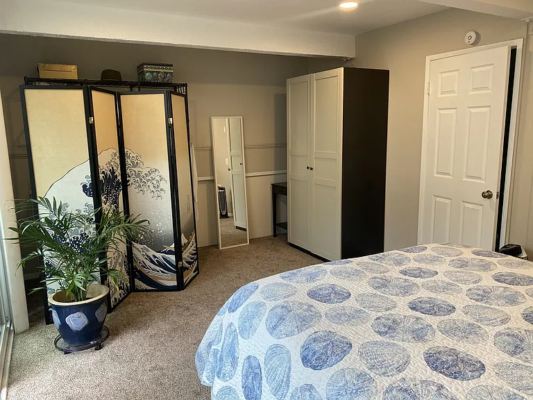 Looking southeast towards wardrobe closet on right and closet shelves and hanging rods on left behind shoji screen