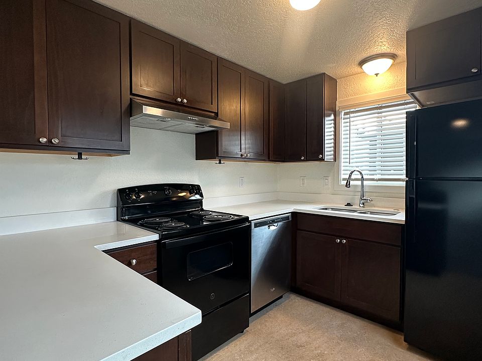 Well-appointed kitchen with stove, vented hood, refrigerator, dishwasher, double sink, and in-sink disposal