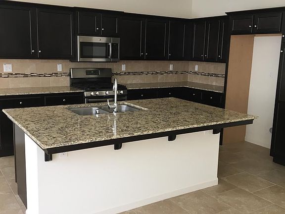 Kitchen with Granite Counter Tops and a center Island. Refrigerator included.
