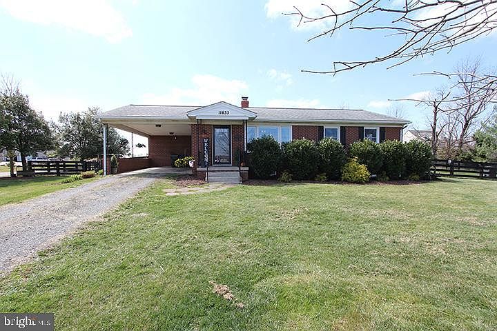 Front of 4 sided brick home with carport