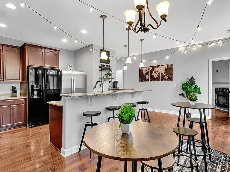 Open kitchen with bar seating, ample cabinetry, and full-size appliances, flowing into a dining area for easy meals.
