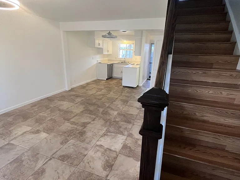 Laminate floor staircase at entry, stone look floor throughout 1st floor. Kitchen with window overlooking private patio