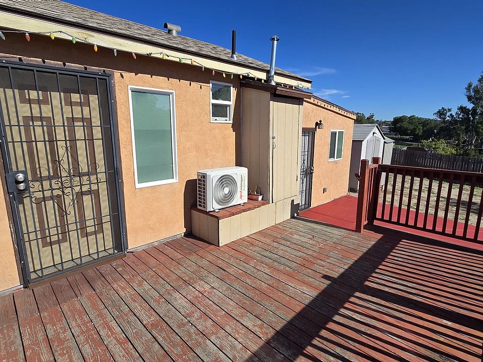 Front entrance featuring a security gate and shared wooden deck area.