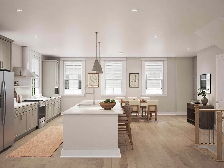 The stylish eat-in kitchen at Fenland Townhomes offers a spacious layout with a large island, high-end finishes, and a dedicated pantry and coffee station for modern living.