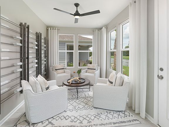 Serene window-filled sunroom that can serve as an at-home get-away for relaxation. - Model Represen