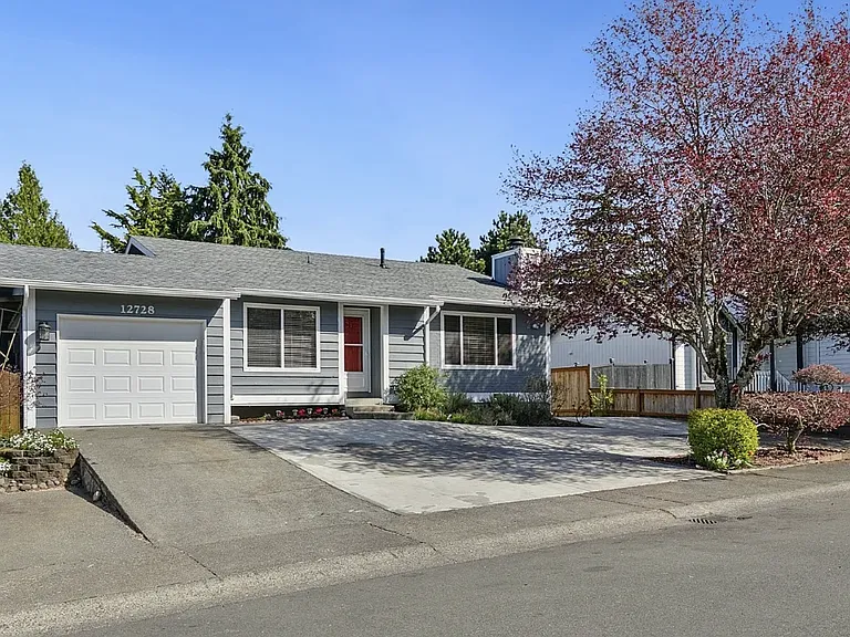 Front of home with parking space in front of the garage and on the street.
