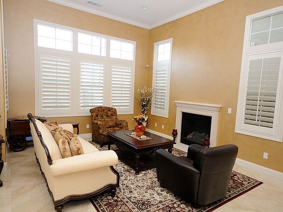 Family room with inviting fireplace and plantation shutters