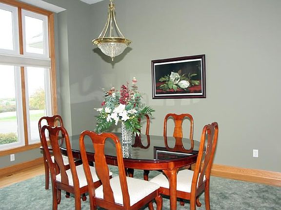 The gorgeous formal dining room features large windows and inlaid carpet.