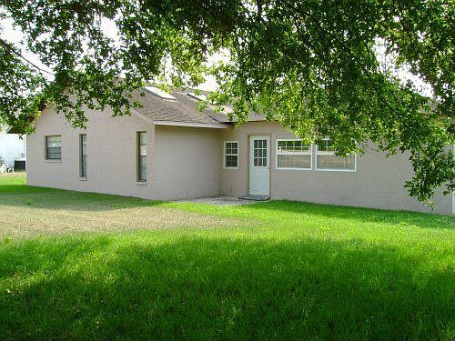 Large spacious back yard partially shaded by large oak